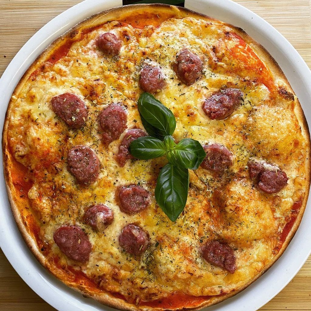 Hier ist die Pizza Salsiccia. Sie wird mit Mozarella beschichtet und mit Salsiccia (Wurst) verziert